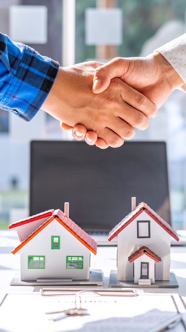 Dos personas Haciendo un trato de compra venta de una casa